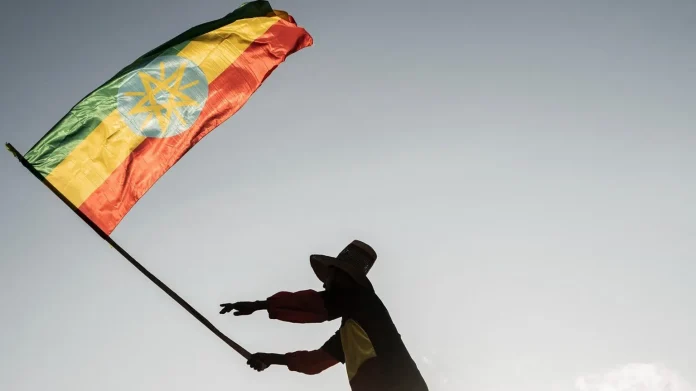 AFP via Getty Images A man waves an Ethiopian flag as he join others gathering in Addis Ababa, Ethiopia, on 22 October 2022.