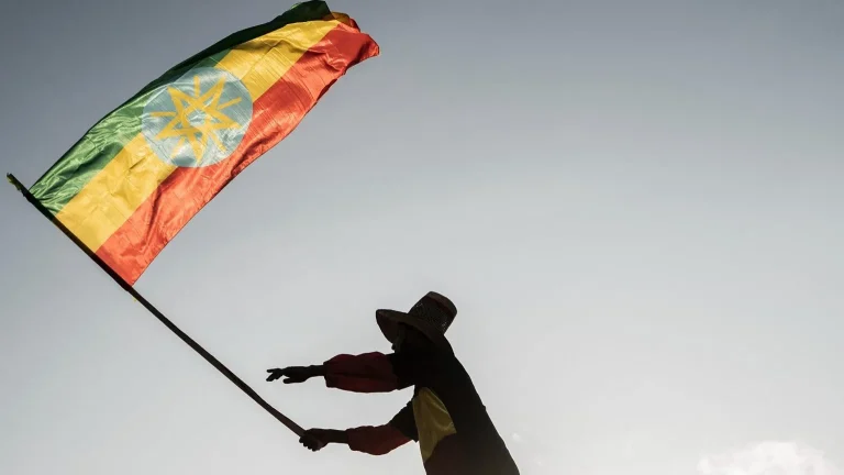 AFP via Getty Images A man waves an Ethiopian flag as he join others gathering in Addis Ababa, Ethiopia, on 22 October 2022.