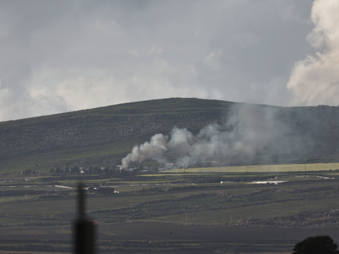 Smoke rises from a village.