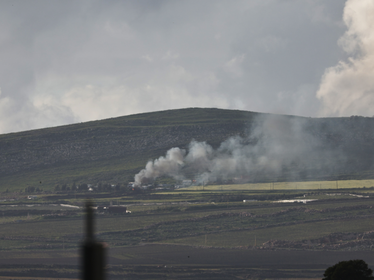 Smoke rises from a village.