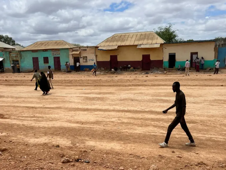 Civilians walk along a deserted street following clashes between Somalia's federal army and forces loyal to the South West state, home to international peacekeepers and humanitarian agencies, in an area affected by drought, conflict and displacement, in Baidoa