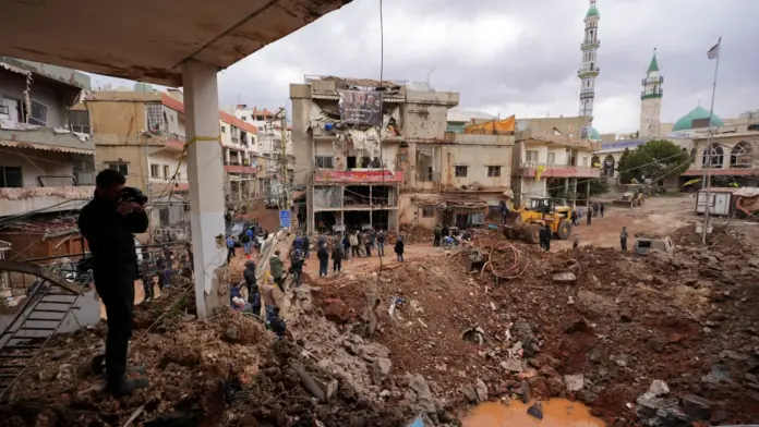 Reuters People inspect the damage where Israel's military carried out an airborne operation that dropped troops overnight, in the town of Nabi Chit.