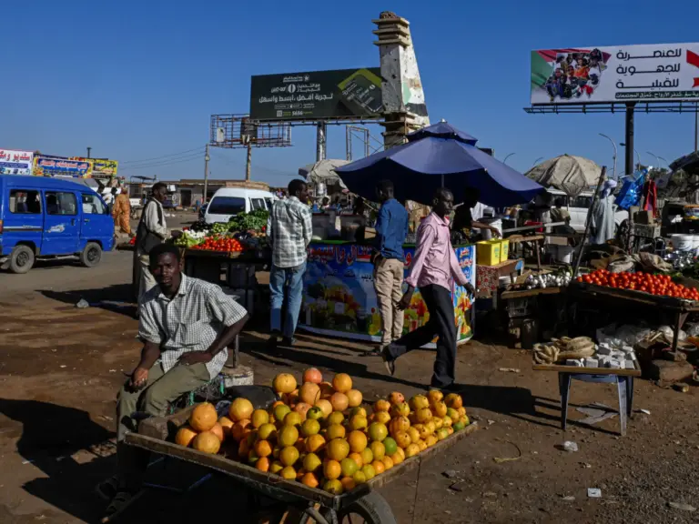 A vendor sits by a fresh produce stall at a local market in the capital Khartoum on April 16, 2026.