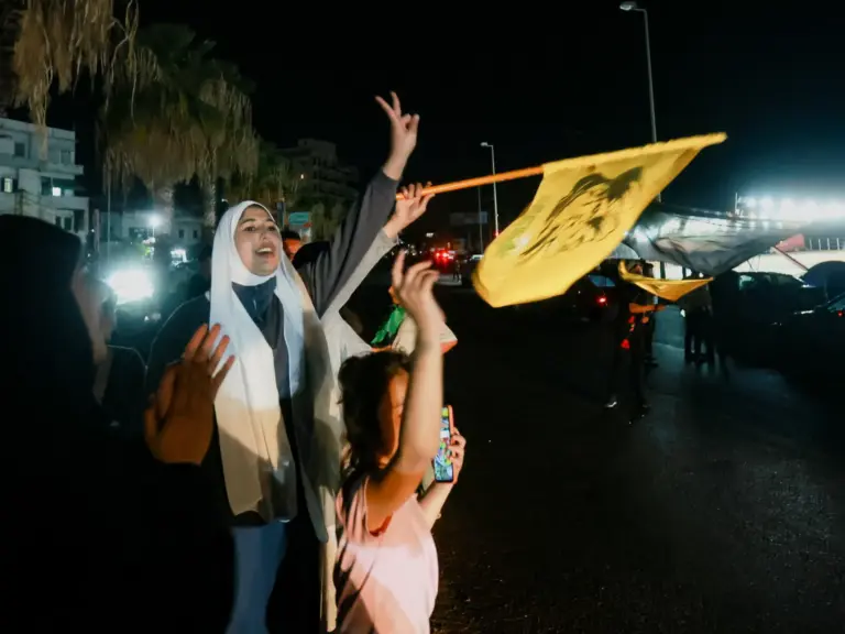 A women and a child celebrate and wave a flag.
