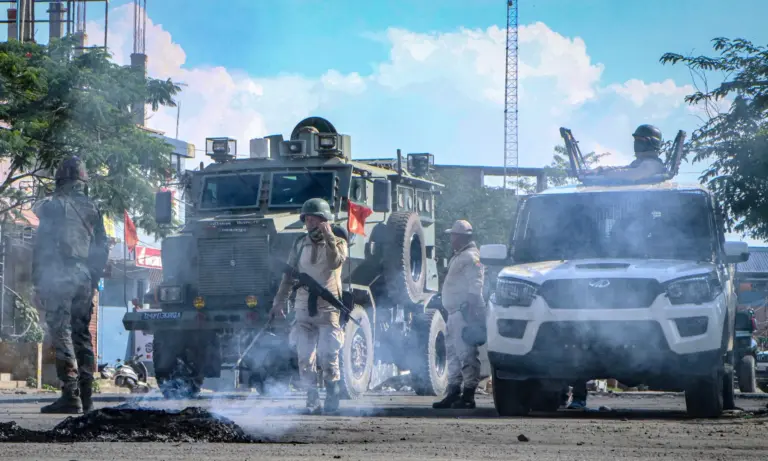 Security vehicles are positioned in the middle of a road.