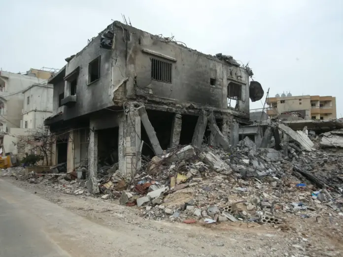 A displaced woman stands outside her home after returning to her hometown of Hannawiyeh in southern Lebanon on April 18, 2026.