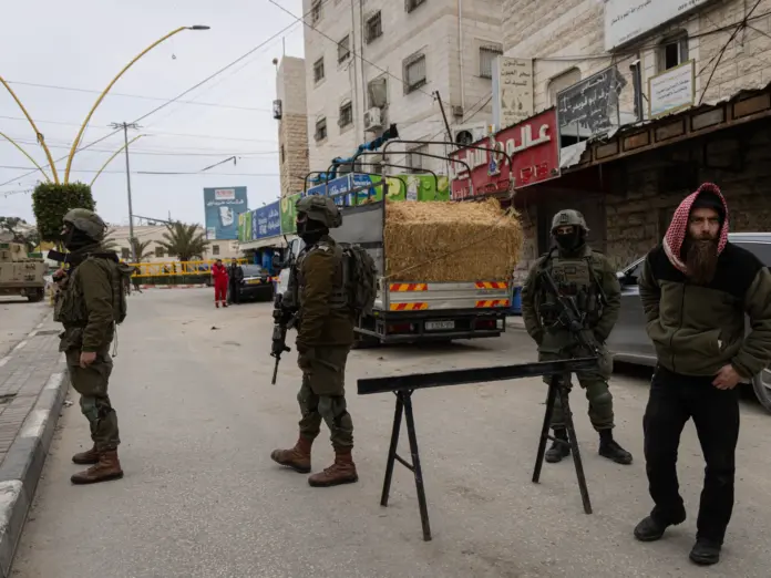HEBRON, WEST BANK - JANUARY 21: Israeli soldiers stand in front of a military checkpoint set up at one of the entrances to the Jabal Johar area on January 21, 2026 in Hebron. Israeli military initiated a 