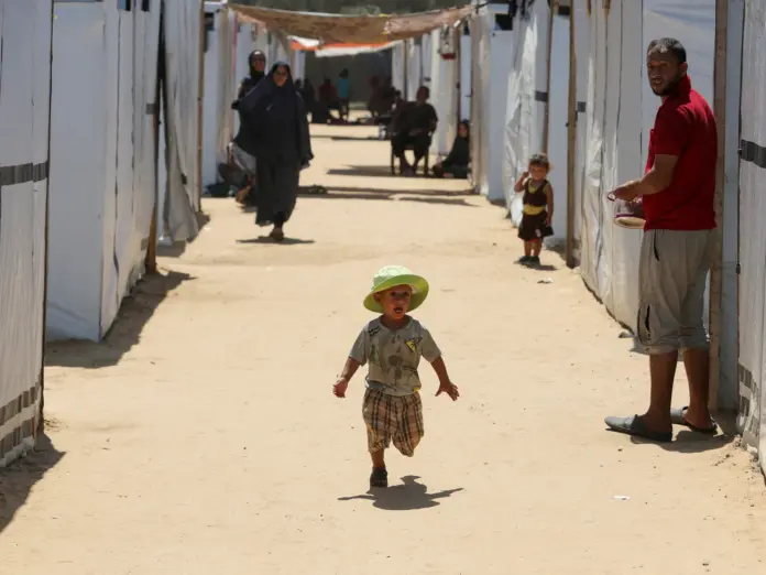 A displaced Palestinian boy runs in a tent camp designated for people with special needs, amid the Israel-Hamas conflict, in Deir Al-Balah in the central Gaza Strip August 8, 2024. REUTERS/Hatem Khaled REFILE - CORRECTING INFORMATION FROM 