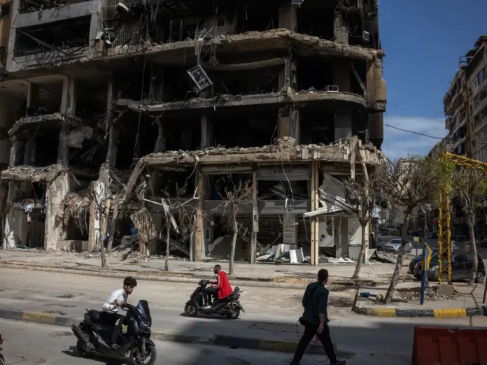 People pass damaged buildings in Beirut.
