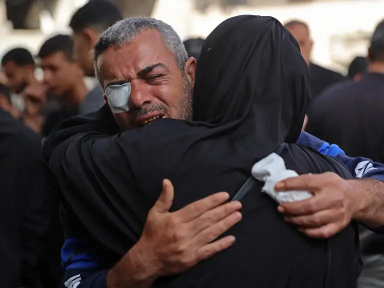 Mourners weep near the bodies of a woman and her two children at a hospital in Gaza City