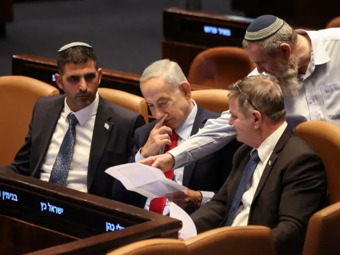 Israeli Prime Minister Benjamin Netanyahu holds a document at the plenum of the Knesset