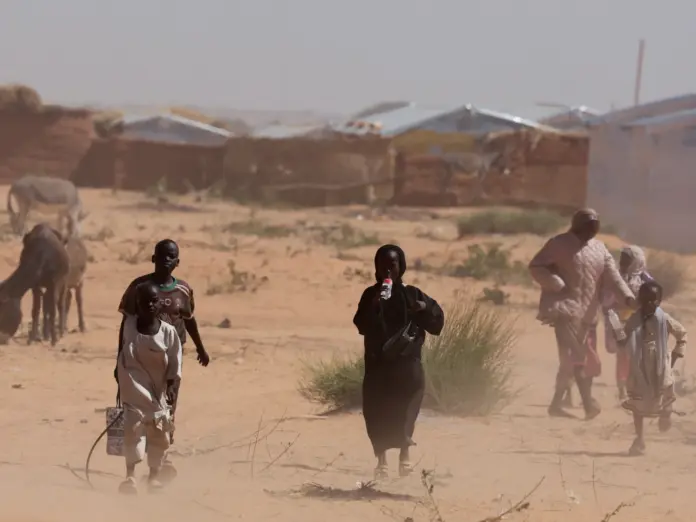 FILE PHOTO: Sudanese refugees from Darfur walk amidst a sandstorm at the Touloum refugee camp, amid ongoing conflict in their country, on the outskirts of the town of Iriba in Wadi Fira province, eastern Chad, November 30, 2025. REUTERS/Amr Abdallah Dalsh/File Photo