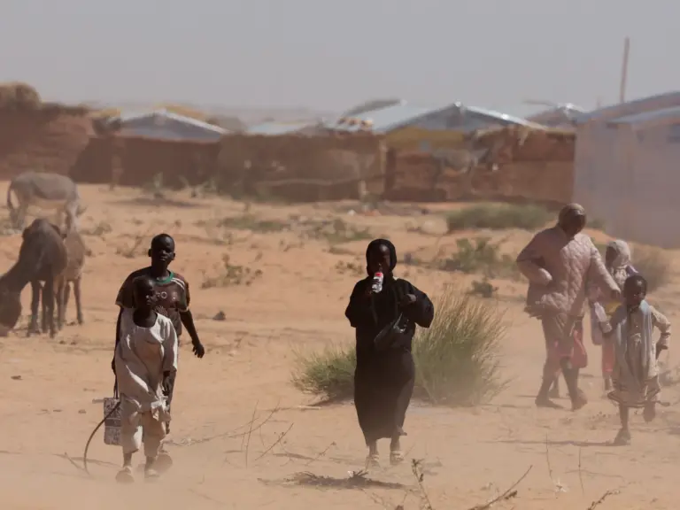FILE PHOTO: Sudanese refugees from Darfur walk amidst a sandstorm at the Touloum refugee camp, amid ongoing conflict in their country, on the outskirts of the town of Iriba in Wadi Fira province, eastern Chad, November 30, 2025. REUTERS/Amr Abdallah Dalsh/File Photo