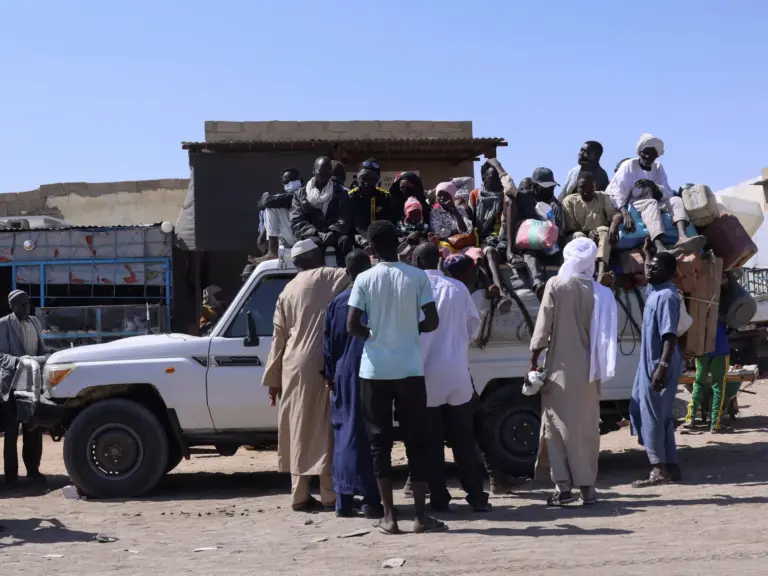 FILE PHOTO: People sit on a pickup truck as they prepare to travel about 250 km south to Adre, on the Chad-Sudan border, at a transport station in Tine, eastern Chad, November 25, 2025. REUTERS/Amr Abdallah Dalsh/File Photo