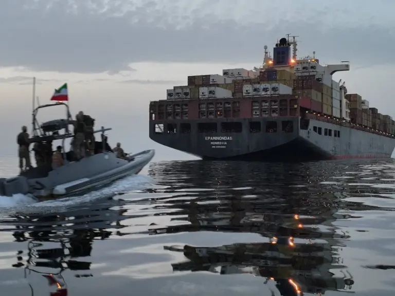 Small boat pursues big ship