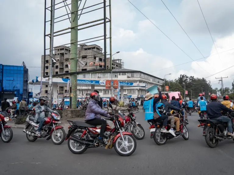 Activists hold signs denouncing the war during a march in Goma, North Kivu, DR Congo on March 12, 2026.