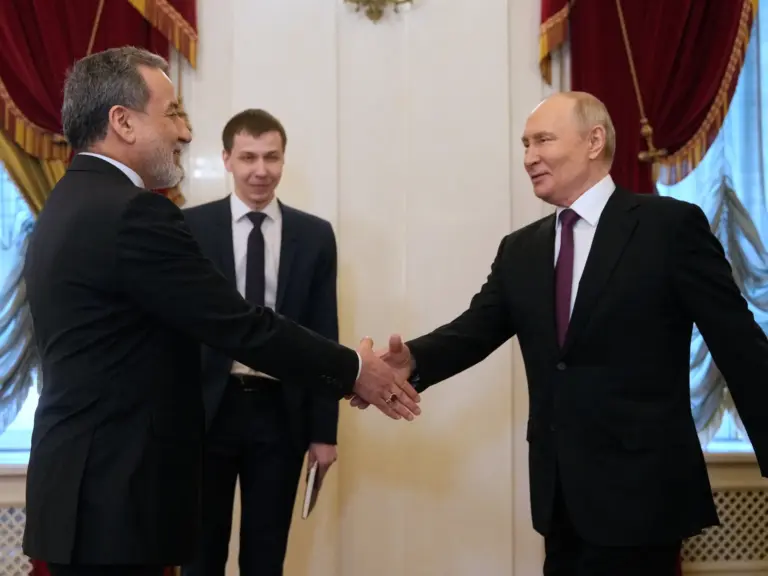 TOPSHOT - Russian President Vladimir Putin shakes hands with Iranian Foreign Minister Abbas Araghchi during their meeting at the Boris Yeltsin Presidential Library in Saint Petersburg on April 27, 2026. (Photo by Dmitry LOVETSKY / POOL / AFP)