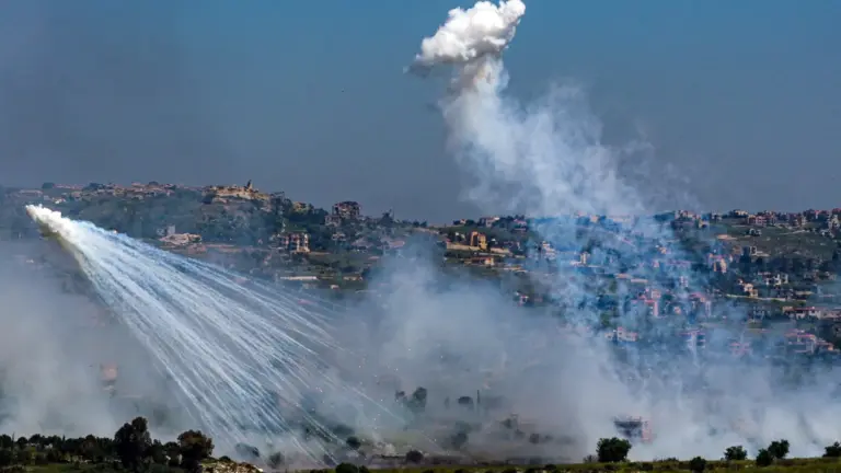 Reuters Two explosions of white smoke in front of a hillside - the Lebanese side of the border with Israel