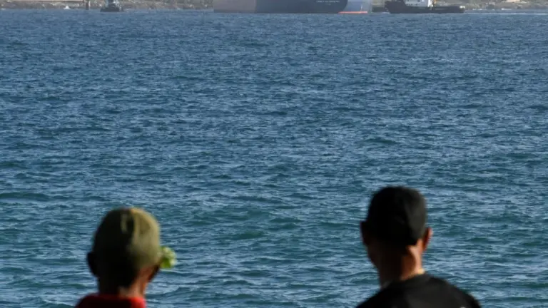 People watch as Anatoly Kolodkin, a Russian-flagged oil tanker carrying some 700,000 barrels of crude, marking the first significant oil delivery since the administration of U.S. President Donald Trump cut off Cuba's fuel supply, is moored while being assisted by tugboats, at Matanzas oil terminal, in Matanzas, Cuba, March 31, 2026. REUTERS/Norlys Perez