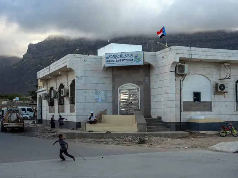 SOCOTRA ISLAND, YEMEN - OCTOBER 16: A boy runs past a branch of the National bank of Yemen in the main town of Hadibu on October 16, 2025 in Socotra, Yemen. Socotra, the largest island in an eponymous archipelago, lies 150 miles off the Horn of Africa, and even farther from mainland Yemen. Its relative isolation has mitigated the impact of Yemen's long-running and stalemated civil war, rendering it safe enough to attract a small but steady stream of foreign tourists. However, it has not been unt